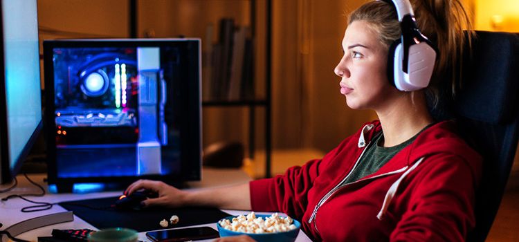 Junge Frau am PC mit Popcorn vor sich