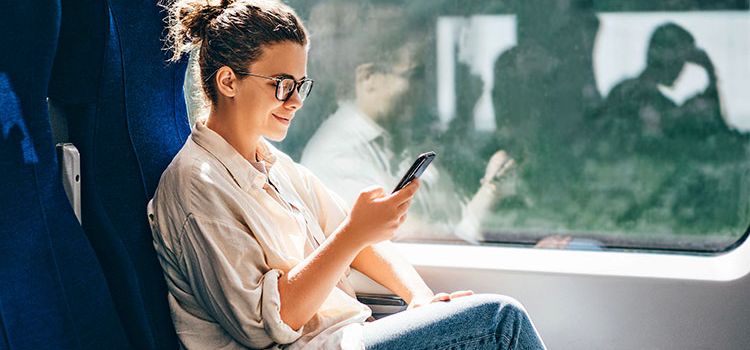 Junge Frau in der Bahn am Smartphone