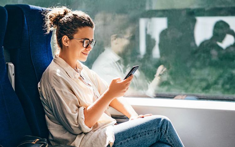 Junge Frau in der Bahn am Smartphone