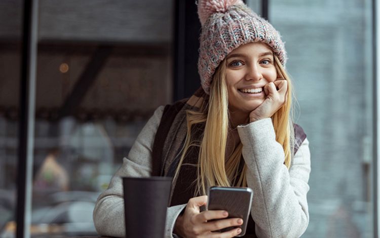 Junge Frau lachend an ihrem Smartphone