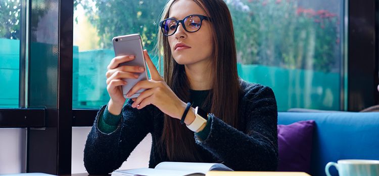 Junge Frau konzentriert am Smartphone