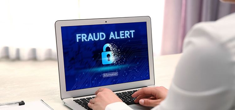 Frau am Laptop mit Hinweis: Fraud Alert