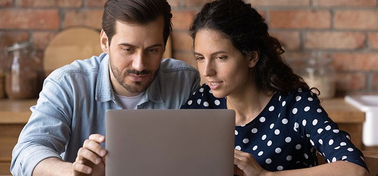 Junges Paar checkt am Laptop Hypothekar-Angebote