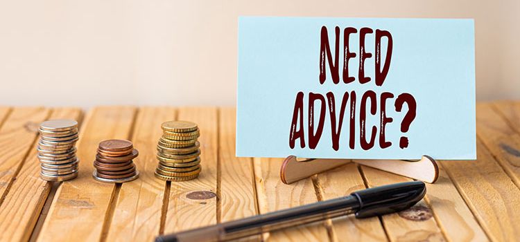 Münzen und Schild mit "Need Advice?" als Symbol für die Notwendigkeit von Finanzberatung