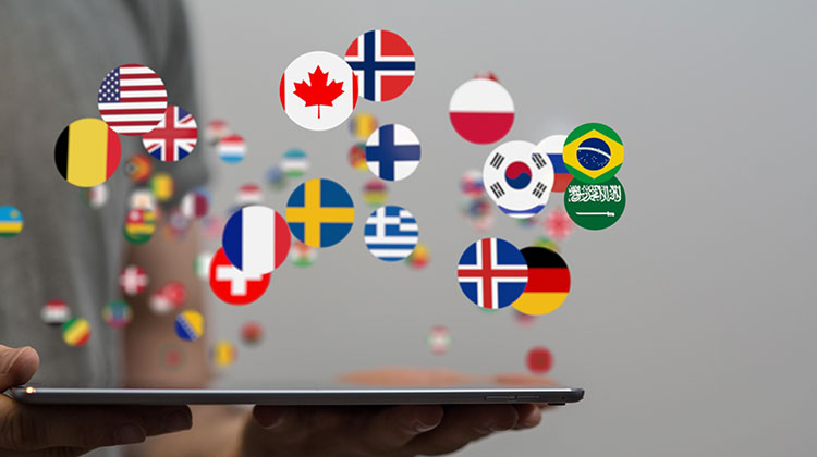 Tablet und zahlreiche Länder-Flaggen in der Luft