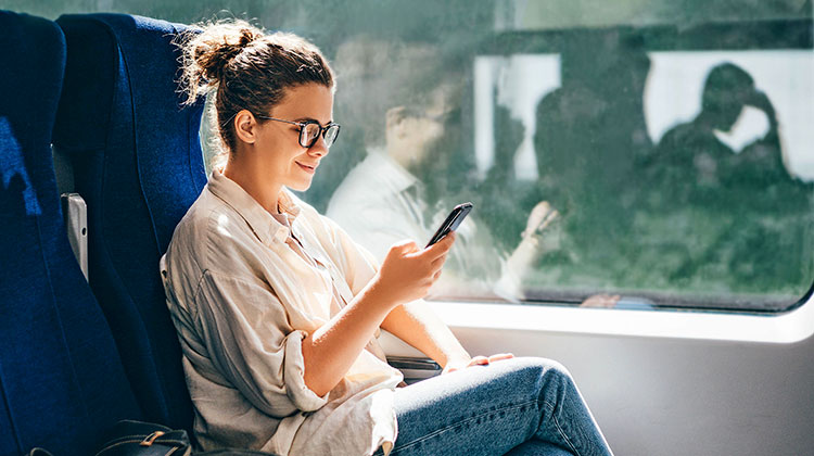 Junge Frau in der Bahn am Smartphone