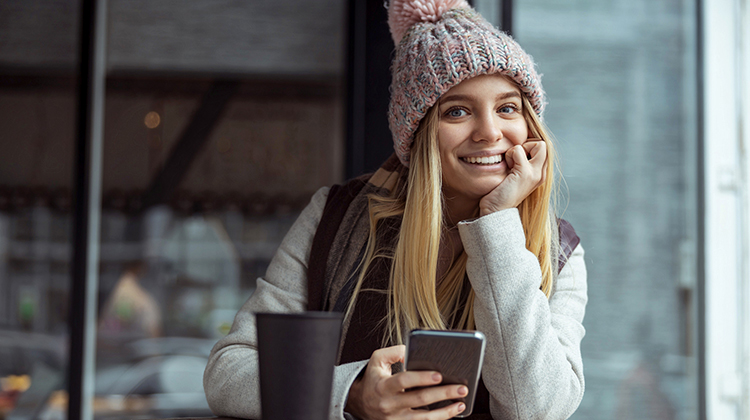 Junge Frau lachend an ihrem Smartphone